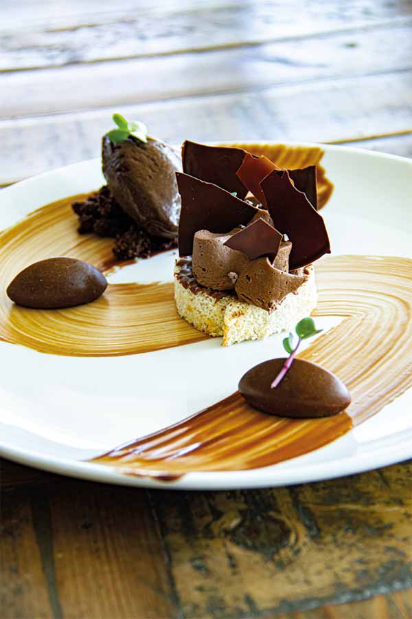 Le Chocolat Crémeux aux chocolats au lait et noir de la maison valrhona, biscuit .amande, glaçage au gianduja et glace au chocolat « Caraïbes »